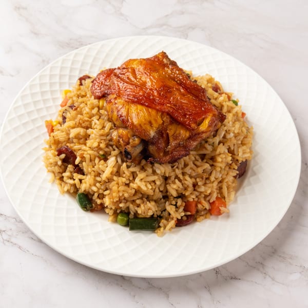 A C Deli's Laos-style fried rice with vegetables, sausage, and a crispy chicken thigh on a white plate.