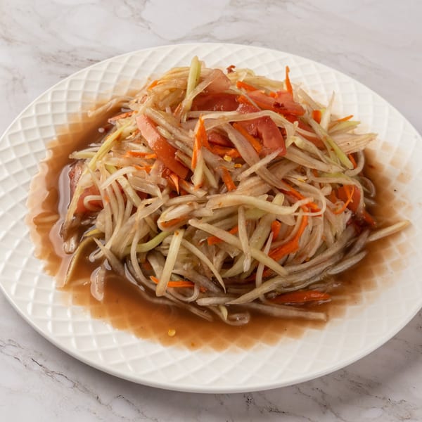 A C Deli's Laos-style papaya salad, with shredded green papaya, carrots, and tomatoes in a savory sauce.