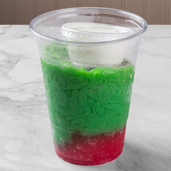 A C Deli's Laos dessert with green noodles and red jelly in a clear cup.